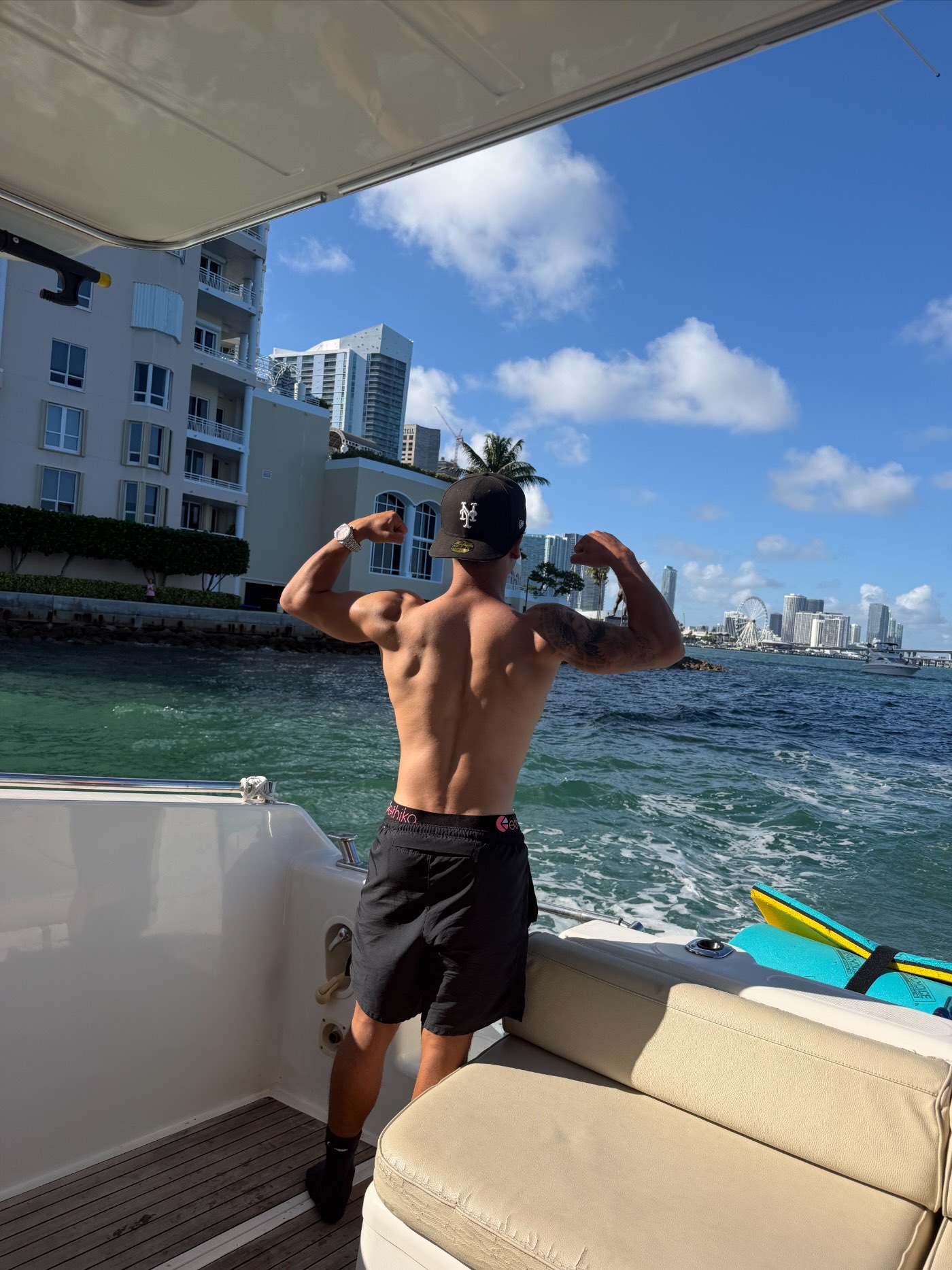 Frank G de espaldas en un bote en la bahía de Miami, mostrando los brazos